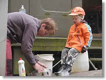 V chladném ránu Hanka myje nádobí a Kubík ji přitom sleduje.